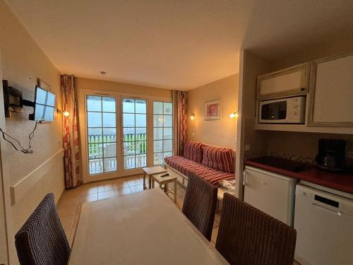 une cuisine et un salon avec une table et des chaises dans l'établissement T2 avec piscine sur la Corniche - FR-1-239-1084, à Urrugne