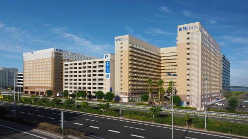 two tall buildings in a city with a highway at Toyoko Inn Chubu International Airport No 2 in Tokoname