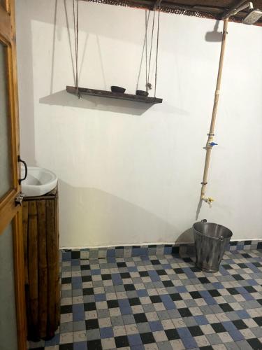 a bathroom with a black and white checkered floor at Yoga Culture Palolem in Palolem