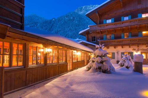 a building with snow covered trees in front of it at Waidringer Hof 4 Sterne Superior in Waidring