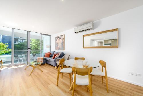 a living room with a table and a couch at Elegant and Cosy Haven in Lively Kingston Foreshore - Hosted by Canstay in Kingston