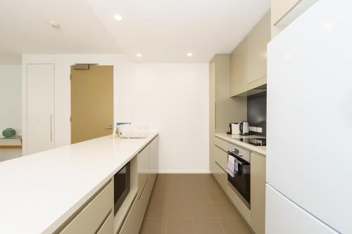 a kitchen with white counters and a white counter top at Elegant and Cosy Haven in Lively Kingston Foreshore - Hosted by Canstay in Kingston