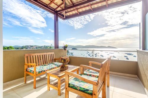a balcony with two chairs and a table with a view of the water at Exclusivo Apê na Orla Bardot Vista para o Mar in Búzios