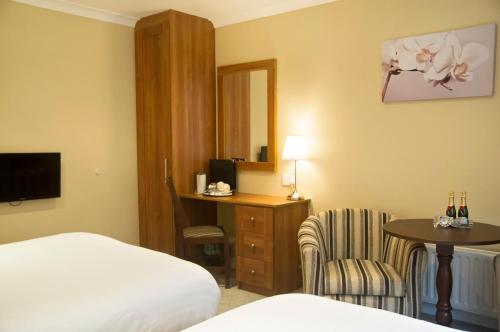 a hotel room with a bed and a desk and a chair at Hillview House in Lusk