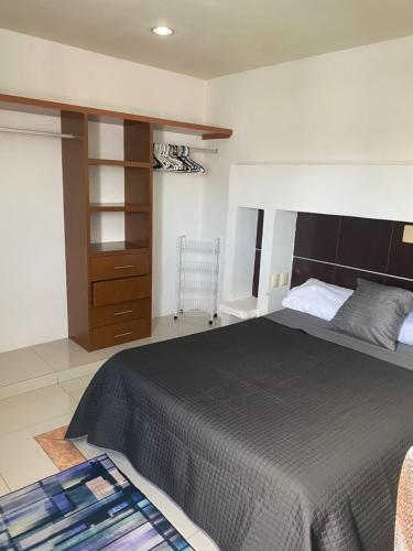 een slaapkamer met een groot bed en een kast bij SUIT HOME EXPRESs in Cancun