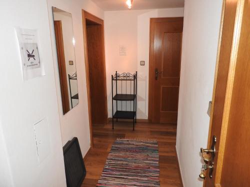 a hallway with a door and a rug at Appartement Alpenhof Wildschönau in Niederau