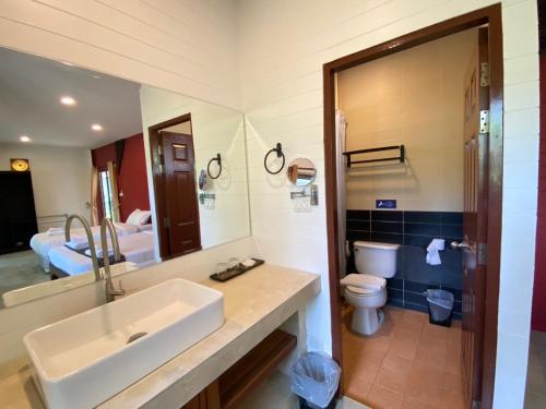 a bathroom with a sink and a toilet and a mirror at ANANTAYA CHIANGMAI BOUTIQUE HOTEL in Chiang Mai