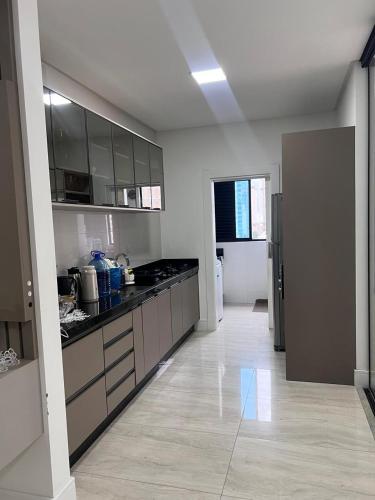 a kitchen with black counter tops and cabinets in a room at Apartamento, quadra mar in Itapema