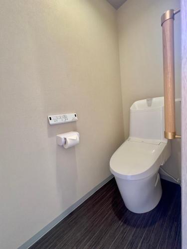 a bathroom with a toilet and two rolls of toilet paper at oni ga shi ma in Osaka