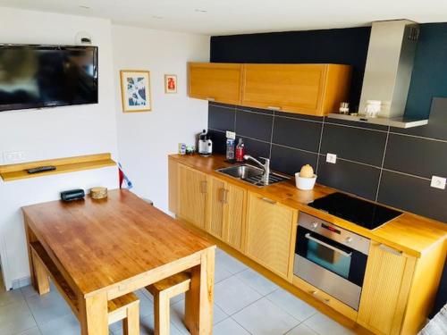 - une cuisine avec une table en bois et un évier dans l'établissement Appartement cosy aux Deux Alpes, au pied des pistes, pour 4 pers, balcon, parking, proche commodités - FR-1-516-211, à Les Deux Alpes
