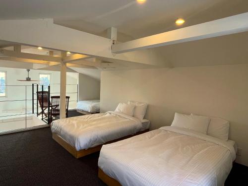 a room with two beds and a table and a chair at Straddie House Niseko Village in Niseko