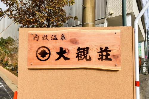 a sign with asian writing on it in front of a building at Aso uchinomaki DAIKANSOU in Aso