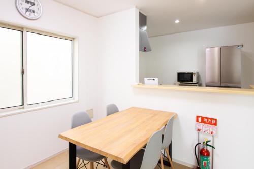 a dining room with a wooden table and chairs at 太宰府 月光の宿 MoonLight inn Free parking 4LDK一軒家 駐車場2台付き in Dazaifu