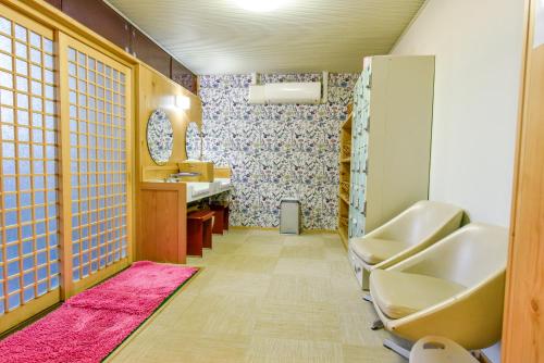 a bathroom with a sink and a mirror at Aso uchinomaki DAIKANSOU in Aso