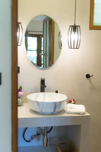 a bathroom with a white sink and a mirror at Palm Garden Resort in Rawai Beach
