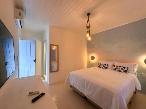 a bedroom with a white bed and a table at Pousada Vilab in Arraial d'Ajuda