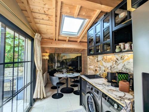 a kitchen with a sink and a table at Charmante Chambre d'Hôtes avec Piscine Chauffée et Terrasse Privative dans le Parc de la Brenne - FR-1-591-597 in Paulnay