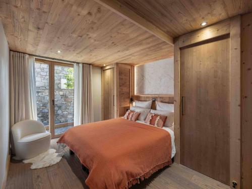 a bedroom with a large bed and a window at Chalet à Méribel, jacuzzi, sauna, 5 chambres, 14 pers. - FR-1-566-73 in Les Allues
