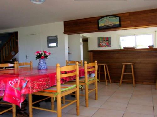 une salle à manger avec une table avec un vase de fleurs dans l'établissement Maison familiale 4 pièces, animaux acceptés, près plage - FR-1-479-164, à Plouharnel