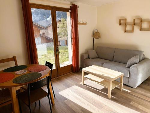 un salon avec un canapé et une table dans l'établissement Charmant 2 pièces avec jardin près téléski - FR-1-464-245, à Pralognan-la-Vanoise
