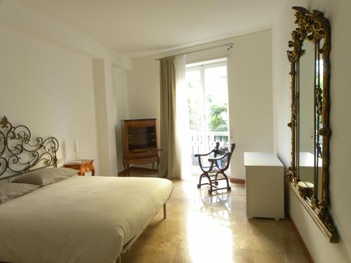 a bedroom with a bed and a mirror and a window at Castedd'House in Cagliari