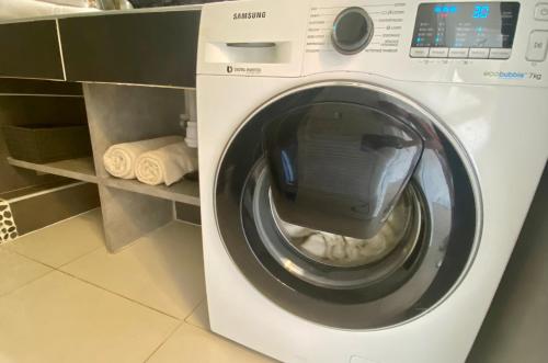 a washing machine with its door open in a kitchen at Excellence Suites Orient Beach Oceanview King-Size Beach Pool Parking in Cul de Sac