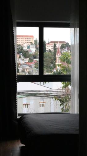 a window in a room with a view of a building at Kimi Uchi Home in Da Lat