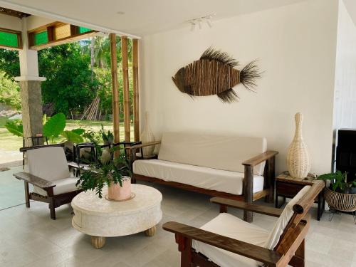 a room with a bed and chairs and a window at Avila's Horizon Dive Resort Santander in Santander