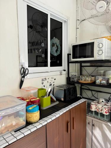 a kitchen with a counter top with a microwave at Magic Hostel in Phi Phi Don