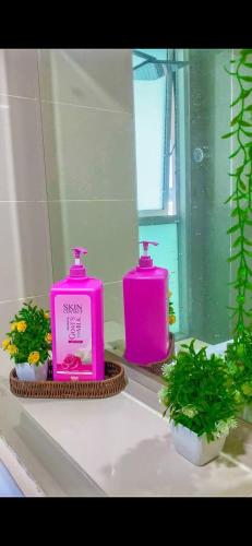 コタキナバルにあるSutera Avenue ira Kkinabalu Homestayの- ピンクのボトル入り石鹸(バスルームの洗面台に座る)