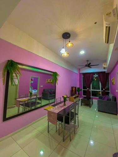 コタキナバルにあるSutera Avenue ira Kkinabalu Homestayの紫の壁のリビングルーム(テーブル、椅子付)