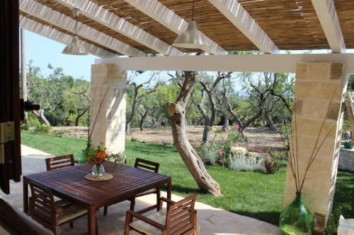 a patio with a table and chairs and a tree at Villa Mest Pepp in Monopoli