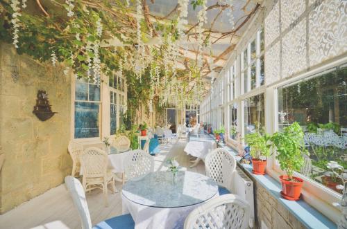 a patio with tables and chairs and windows at Enchanted Manor in Niton