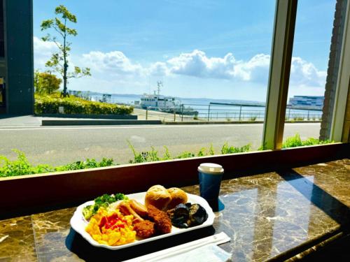 a plate of food on a table with a view of the ocean at Toyoko Inn Chubu International Airport No1 in Tokoname