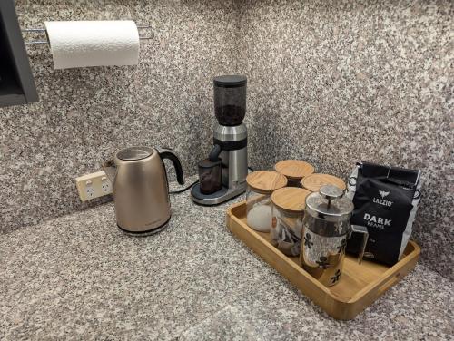 a coffee maker on a wooden tray on a counter at Stately Bowral Designer Home in Bowral