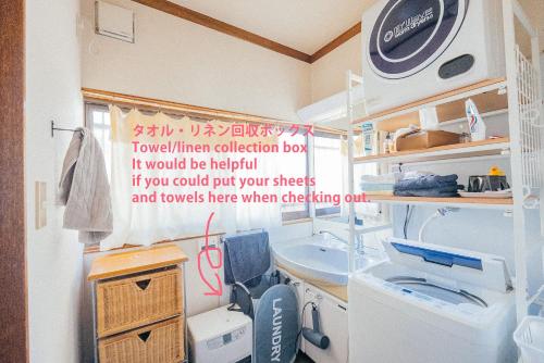 a bathroom with a sink and a washing machine at yururito guesthouse in Matsumoto