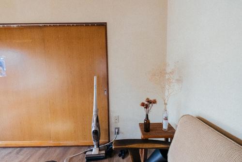 a living room with a tv and a wooden door at yururito guesthouse in Matsumoto