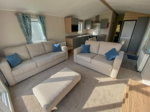 a living room with two couches and a kitchen at Cayton Bay Kestrel40 in Cayton
