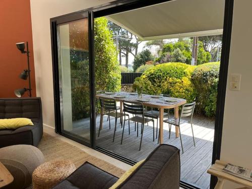 une salle à manger avec une table et des chaises sur un patio dans l'établissement Maison contemporaine 6 couchages, 50m de la plage, à La Trinité-sur-Mer