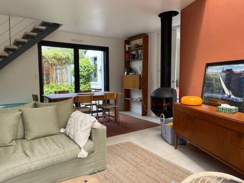un salon avec un canapé et une cheminée dans l'établissement Maison contemporaine 6 couchages, 50m de la plage, à La Trinité-sur-Mer