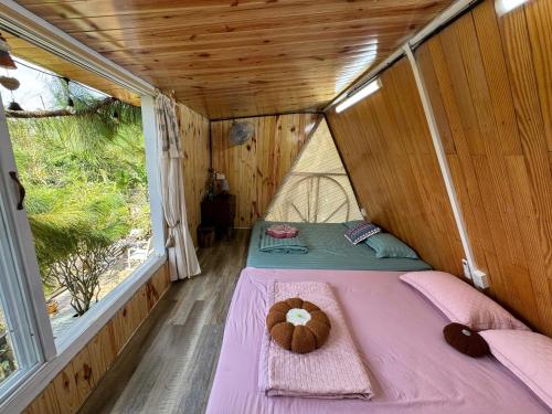 a small room with a bed with a teddy bear on it at HomeTa Homestay in Bao Loc