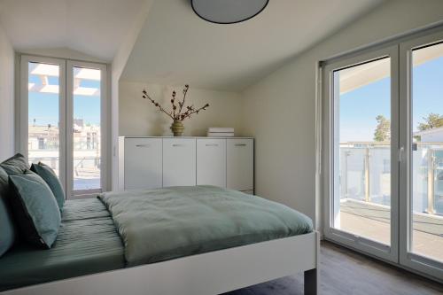a bedroom with a bed and large windows at Maisonette-Apartment C11 Zwei Balkone, zwei Terrassen im "Pine Hill Resort" in Zirchow