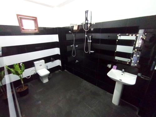 un bagno bianco e nero con servizi igienici e lavandino di Seoul Beach Mirissa a Mirissa