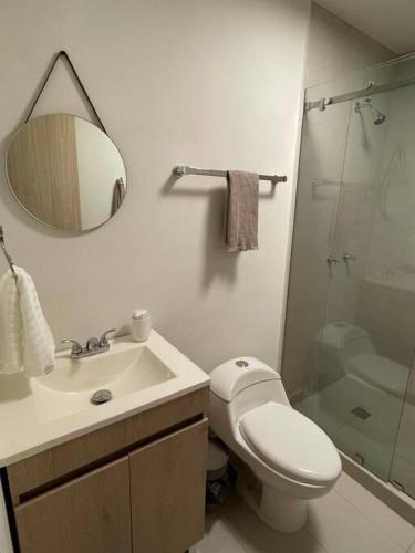 a bathroom with a toilet and a sink and a mirror at Prime Monterrey Stay 7 in Monterrey