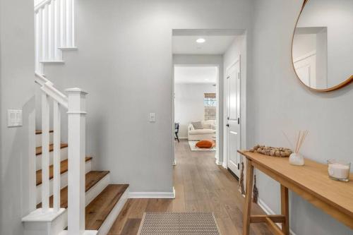 pasillo con paredes blancas y escalera con espejo en GOODE HOMES Luxury Villa with Community Pool and Spa, en Santa Clarita