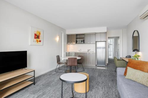 an apartment living room with a couch and a kitchen at Quest Caroline Springs in Caroline Springs