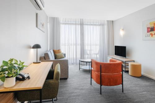 a living room with a couch and a table at Quest Caroline Springs in Caroline Springs