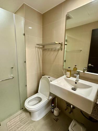 a bathroom with a toilet and a sink and a mirror at The Verdin in General Trias
