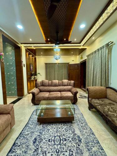 a living room with couches and a coffee table at Ultra Luxurious 4 Floor Villa in Bengaluru