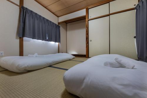 two beds sitting in a room with atained at Kaori 香 in Osaka